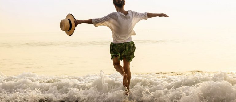 Kostenlos reisen und das Feeling am Strand genießen wie die Frau auf dem Foto. Wie das geht, erfahrt ihr in diesem Artikel.