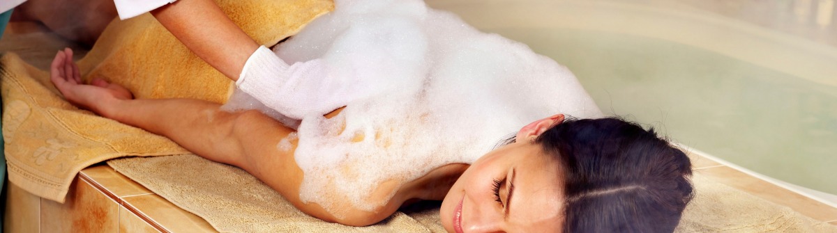 Frau wird im Hamam eingeseift und entspannt im türkischen Dampfbad.