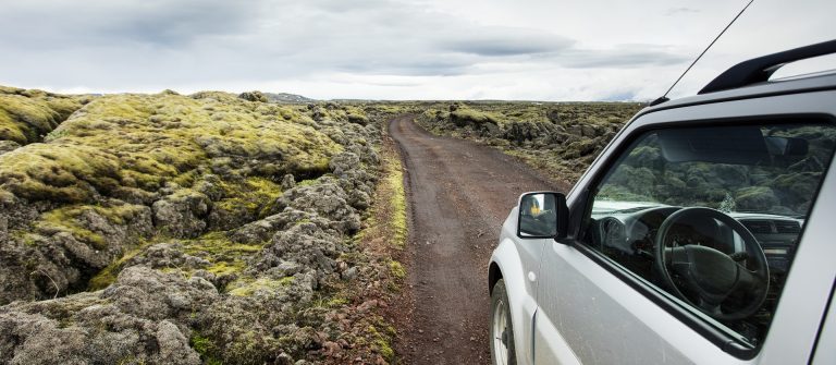 Ein kleiner Jeep fährt durch Island