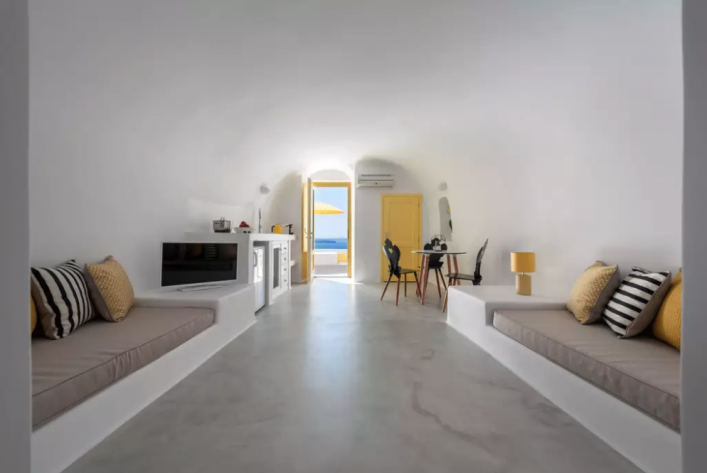 Der Wohnraum des zweiten Apartments ist Weiß- und Gelbtönen gehalten.