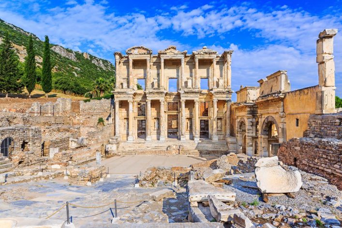 Antike Ruinen der Celsus-Bibliothek in Ephesos an der türkischen Ägäis, mit Säulen und Statuennischen vor blauem Himmel.