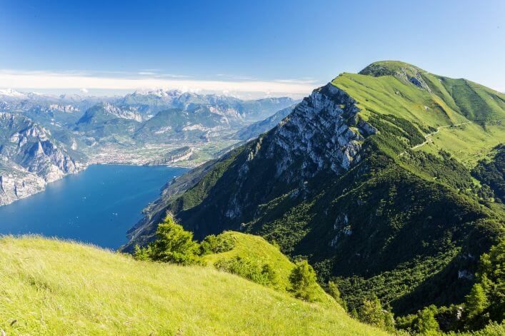 Der Ausblick vom Monte Baldo über die grüne Bergkette und den Gardasee.
