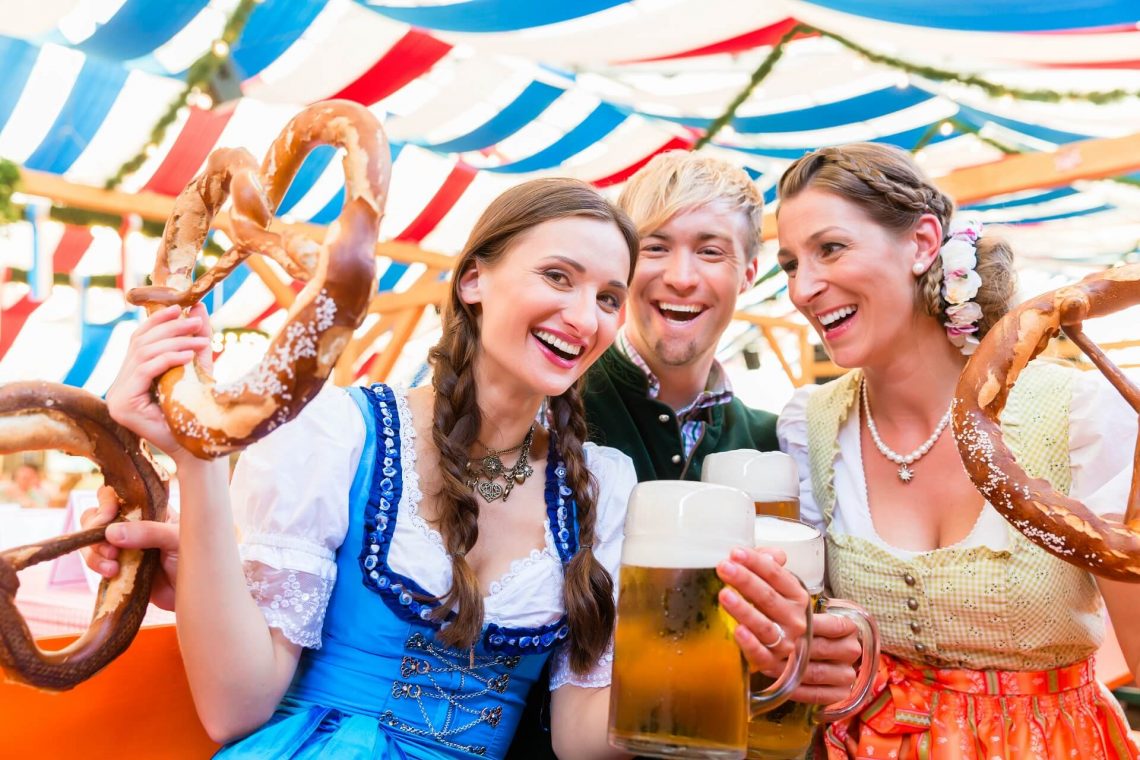 Besucher auf dem Oktoberfest mit Bier und Brezel