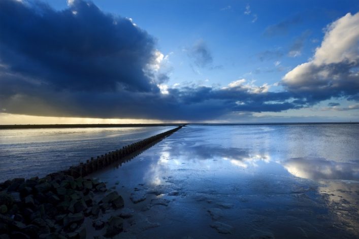 Donkere luchten boven de waddenzee bij de pier van Holwerd