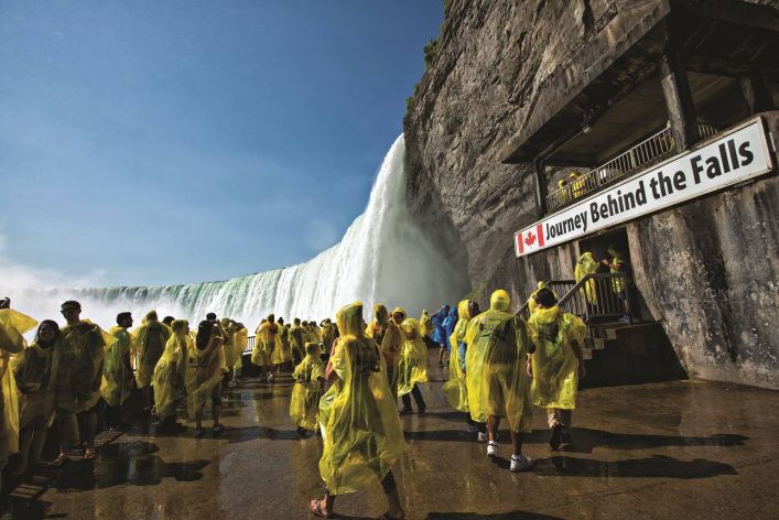 Urlauber in Regenjacken besichtigen die Niagarafälle