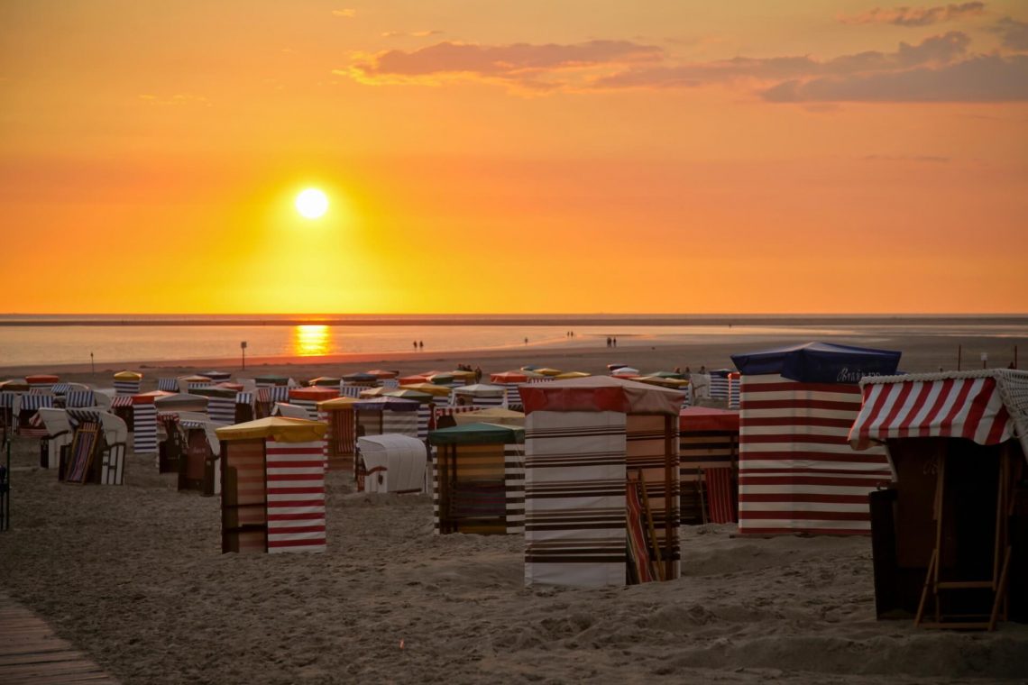 Strandkörbe und Zelte bei Sonnenuntergang am Strand auf Borkum.