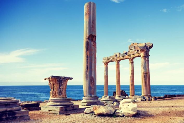 Antike Säulen des Apollon-Tempels in Side an der türkischen Riviera, vor blauem Himmel und Meereshorizont.