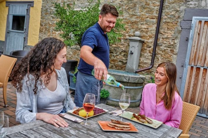 Zwei Frauen genießen regionale Spezialitäten und regionalen Wein